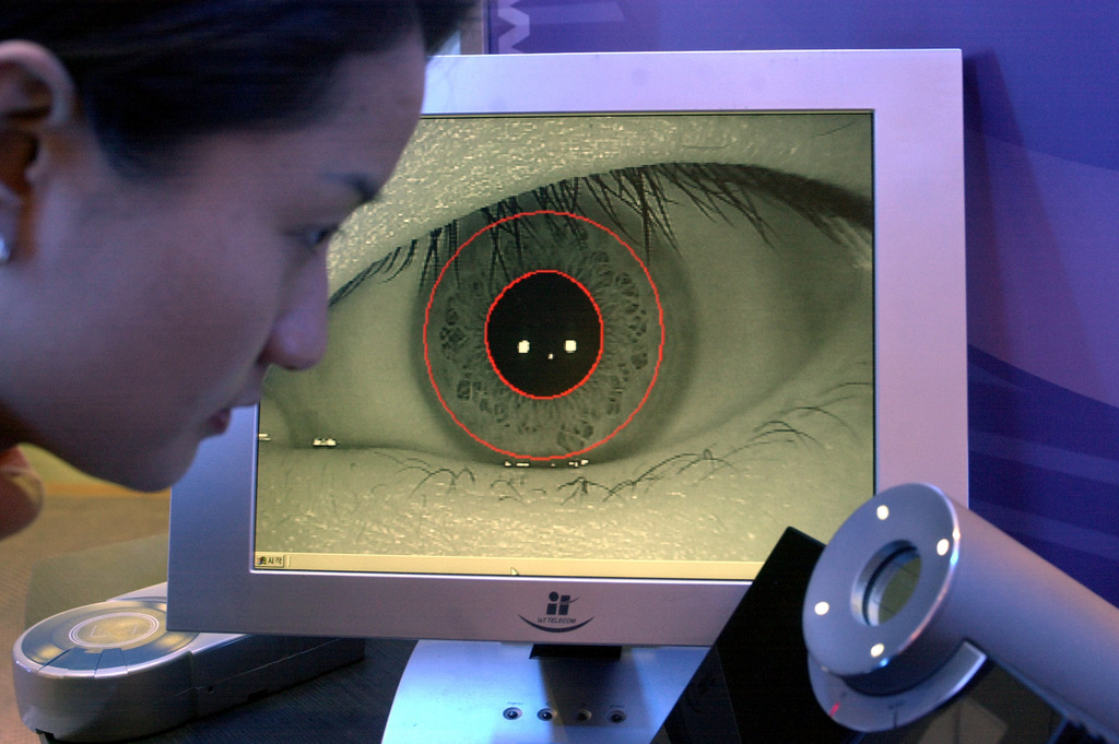 Lee Se-Jung looks into a camera as her eye is seen on the screen beyond, during a presentation of the TrueEYE iris scan system by Korean company Senex Technologies, Thursday March 14, 2002 during the CeBIT computer fair in Hanover, northern Germany. The iris scan system is considered to be the safest and securest item among other biometric items and existing security devices. EDS: Picture was taken in fluorescent light. (KEYSTONE/AP Photo/Fabian Bimmer)