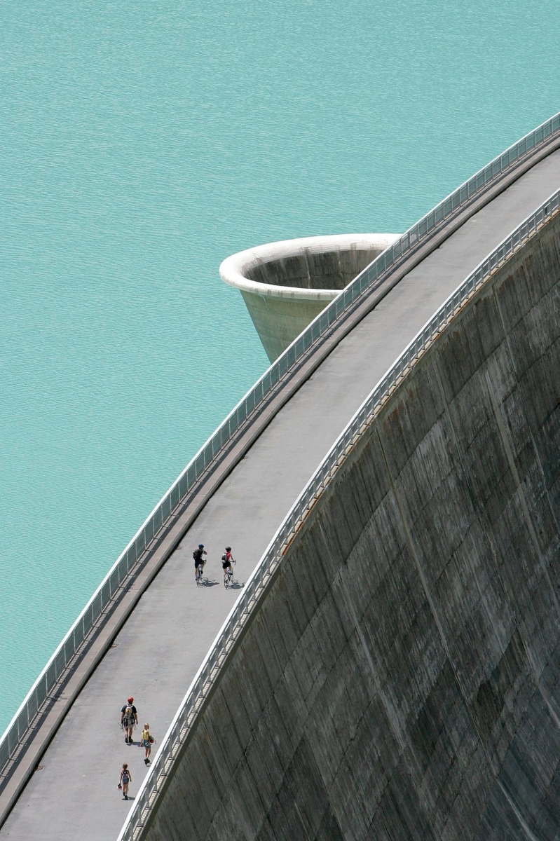 ZUR MK VON ECONOMIESUISSE UND WWF ZUM TRIALOG ZUR ENERGIESTRATEGIE 2050 STELLEN WIR IHNEN AM FREITAG, 23. AUGUST 2013, FOLGENDES ARCHIVBILD ZUR VERFUEGUNG - Des personnes se promenent sur le barrage de Moiry, le vendredi 21 juillet 2006. Le barrage, haut de 148 metres et long de 610m, a ete mis en service en 1958, de type voute. Il se situe dans le Val d'Anniviers, au fond de la vallee de Grimentz.  (KEYSTONE/Olivier Maire) SCHWEIZ ENERGIESTRATEGIE 2050