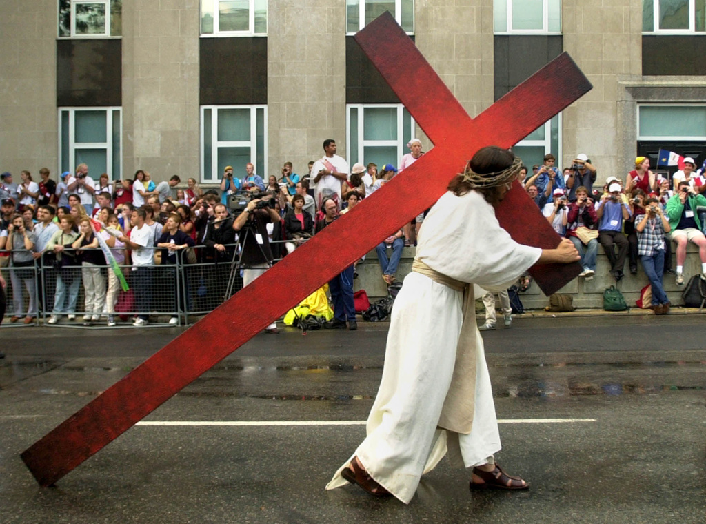 Robert Legere of St. Louis de Kent, New Brunswick, who is portraying Jesus, carries the cross through the streets of Toronto during the stations of the cross , during World Youth Day, Friday evening July 26, 2002. (AP Photo/Robert F. Bukaty)