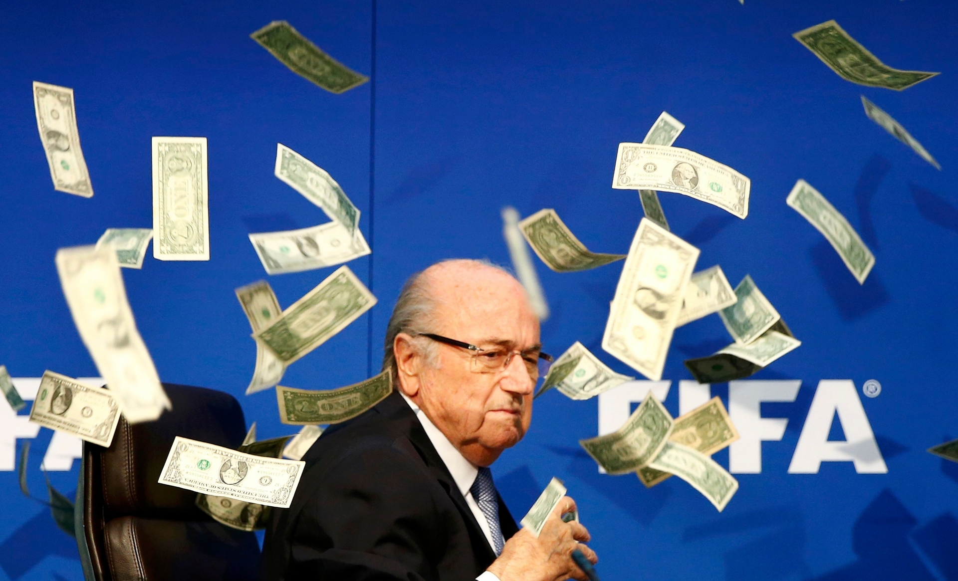 British comedian known as Lee Nelson (unseen) throws banknotes at FIFA President Sepp Blatter as he arrives for a news conference after the Extraordinary FIFA Executive Committee Meeting at the FIFA headquarters in Zurich, Switzerland July 20, 2015. World football's troubled governing body FIFA will vote for a new president, to replace Sepp Blatter, at a special congress to be held on February 26 in Zurich, the organisation said on Monday.       REUTERS/Arnd Wiegmann blatter Fifa, protesta dell'attore britannico Lee Nelson contro Sepp Blatter