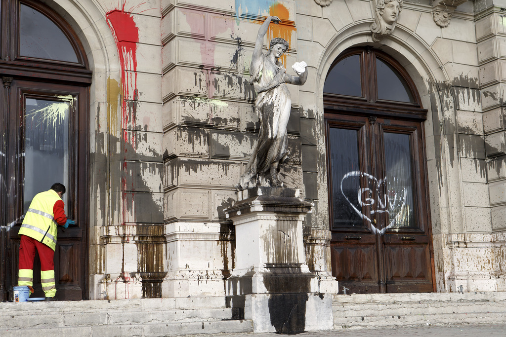 Un nettoyeur de la ville de Genève nettoie la façade du Grand Théâtre, souillée de peintures et de tags.