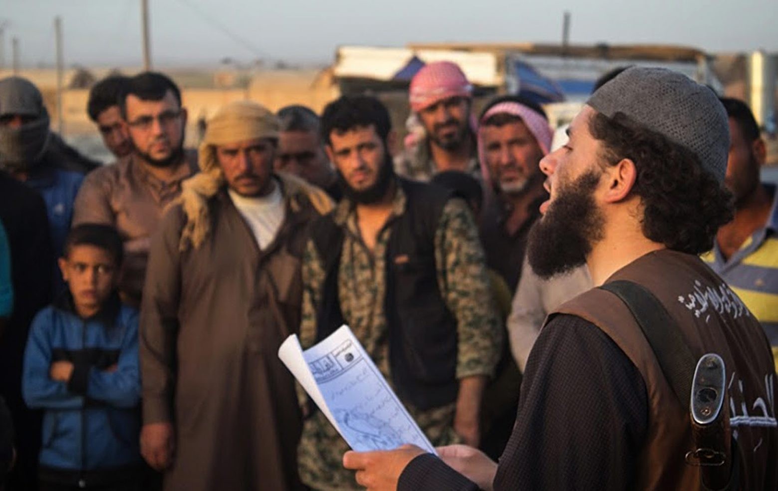 In this photo released on May 14, 2015 by a militant website, which has been verified and is consistent with other AP reporting, a member of the Islamic State group's vice police known as "Hisba," right, reads a verdict handed down by an Islamic court sentencing many they accused of adultery to lashing, in Raqqa City, Syria. (Militant website via AP) Inside The Caliphate Nation Of Fear