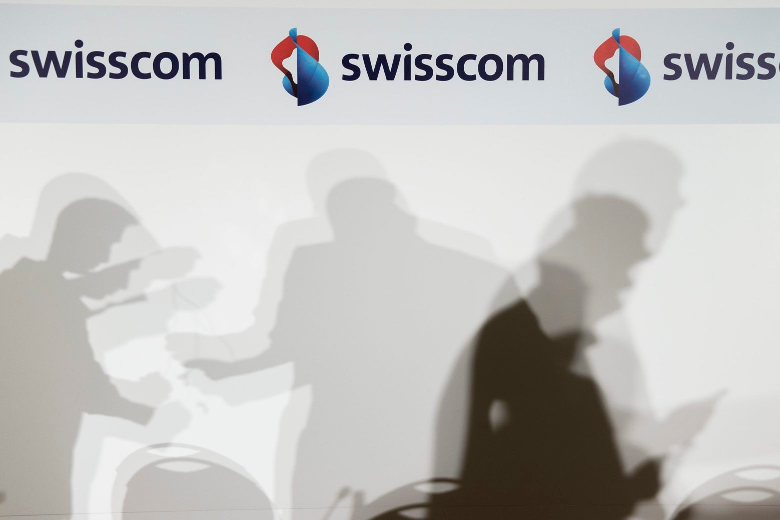 ARCHIV - ZUM GEWINNKNICK BEIM GROESSTEN SCHWEIZER TELEKOMKONZERN SWISSCOM STELLEN WIR IHNEN FOLGENDES ARCHIVBILD ZUR VERFUEGUNG. - Die Schatten von Journalisten bewegen sich an der Bilanzmedienkonferenz der Swisscom am Donnerstag, 5. Februar 2015, in Zuerich. (KEYSTONE/Ennio Leanza) SCHWEIZ SWISSCOM