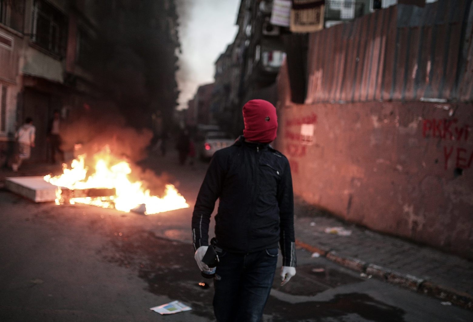 A masked man prepares to throw a petrol bomb toward police who use water cannons and teargas to disperse people protesting against security operations against Kurdish rebels in southeastern Turkey, in Istanbul, Sunday, Dec. 20, 2015. Security forces have killed more than 100 Kurdish rebels in last four days in southeast Turkey, news agencies' reports say. The government imposed curfews in the mainly Kurdish towns of Cizre and Silopi as the security forces battle militants linked to the Kurdistan Workers' Party, or PKK who have moved their fight for autonomy to some towns and city neighborhoods.(AP Photo/Cagdas Erdogan) Turkey Kurds