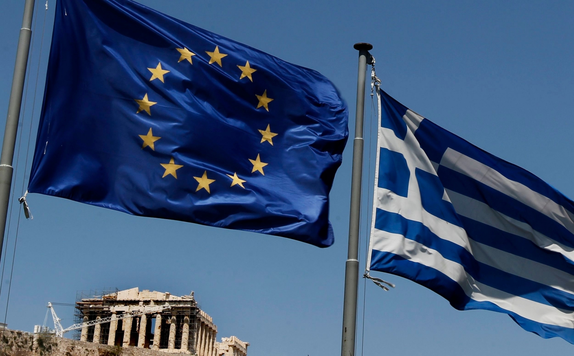 A European Union left and the Greek flag wave above the ancient Parthenon temple, at the Acropolis Hill, in Athens on Monday, July 11, 2011.Greece's Socialist government on Monday named a five-member committee to head a euro50 billion ($71.2 billion) privatization program aimed at easing the country's euro340 billion ($484.2 billion) national debt. (AP Photo/Petros Giannakouris) Greece Financial Crisis