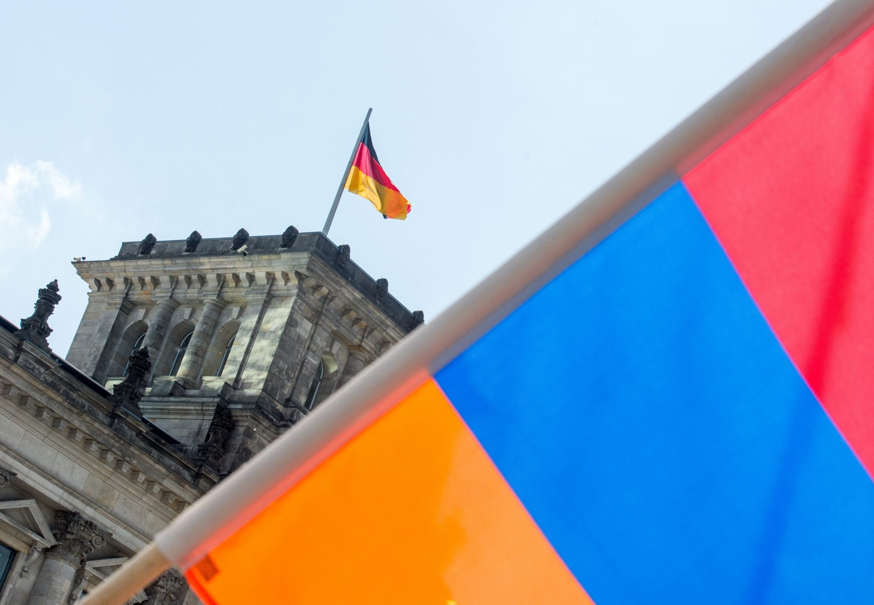 epa05342327 An Armenian flag in front of the Reichstag building in Berlin, Germany, 02 June 2016. The German Bundestag adopted a resolution to name the 1915/16 massacre of the Armeinians by the Ottoman Empire as genocide. Turkey, the legal successor of the Ottoman Empire, had cautioned against the acceptance of the resolution.  EPA/ALEXANDER HEINL GERMANY PARLIAMENT TURKEY ARMENIA GENOCIDE