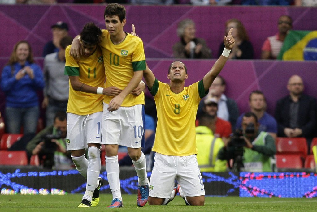 Brazil's Romulo, center, celebrates alongside teammates Neymar, left, and Oscar after scoring against South Korea during their semifinal men's soccer match at the 2012 London Summer Olympics, Tuesday, Aug. 7, 2012, at Old Trafford Stadium in Manchester, England. (AP Photo/Jon Super)
