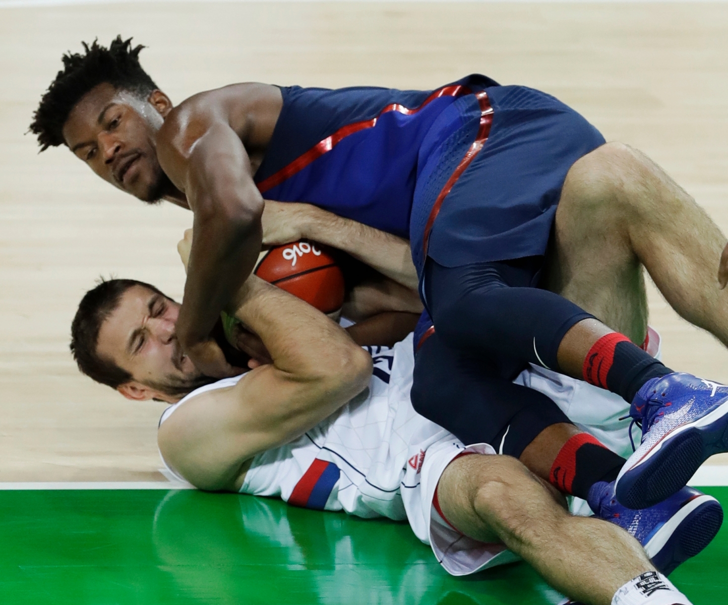 Serbia's Stefan Bircevic, bottom, and United States' Jimmy Butler battle for the ball during the men's gold medal basketball game at the 2016 Summer Olympics in Rio de Janeiro, Brazil, Sunday, Aug. 21, 2016. (AP Photo/Charlie Neibergall) Rio Olympics Basketball Men
