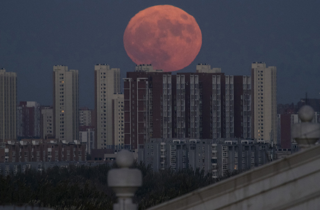 La super pleine Lune s'est déjà levée derrière les buildings de Pékin, en Chine.