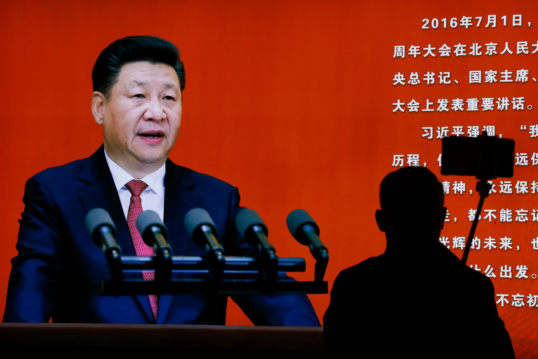 A man takes a selfie near a picture of Chinese President Xi Jinping on display at an exhibition on the Long March at the military museum in Beijing, Monday, Oct. 24, 2016. Having punished more than a million Communist Party members for corruption, Chinese President Xi Jinping will use a key meeting that started Monday to drive home the message that his signature anti-graft campaign is far from over and that his authority remains undiminished. (AP Photo/Andy Wong) China Politics