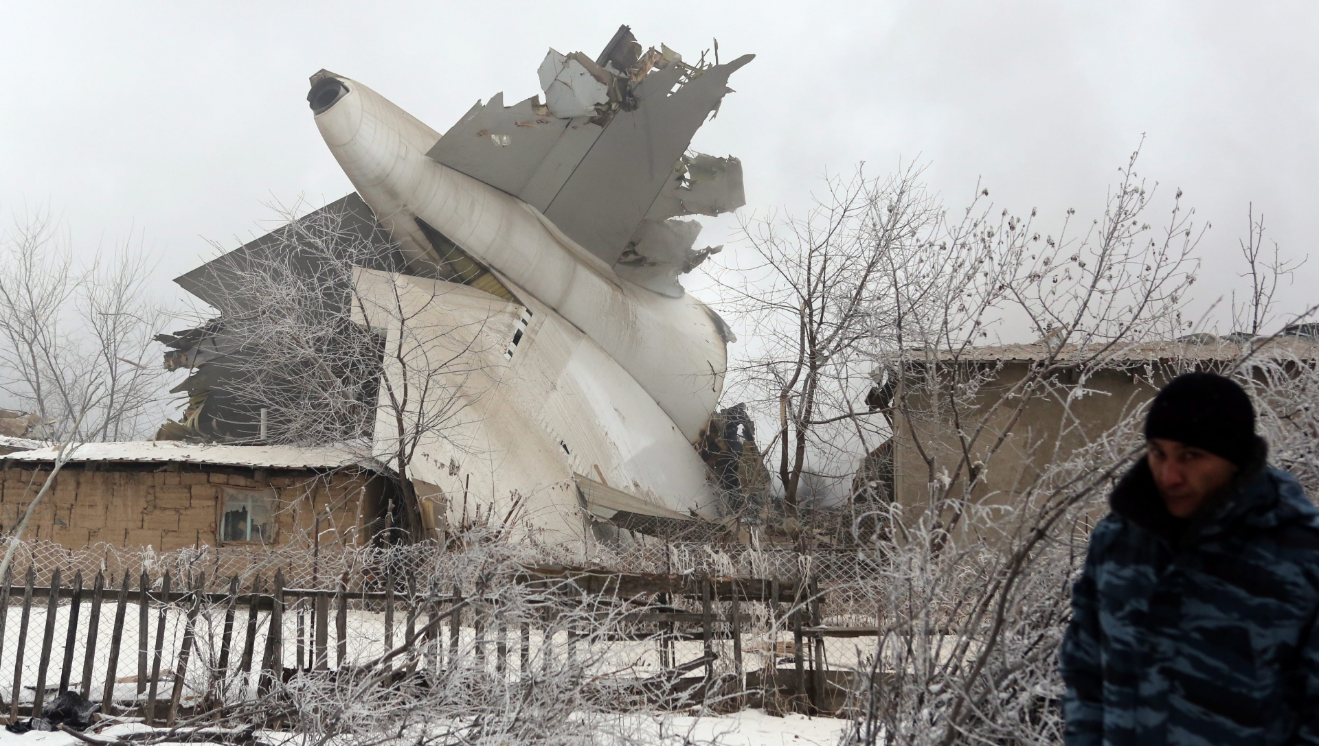 epa05720983 Parts of the plane rise between damaged houses at the site of an airplane crash near the airport Manas, 30 kilometers from Bishkek, Kyrgyzstan, 16 January 2017. A Turkish Boeing 747-400 cargo plane crashed on a village near the capital of Kyrgyzstan, destroying 32 houses and killing at least 37 people, according to reports.  EPA/IGOR KOVALENKO KYRGYZSTAN AIRPLANE CRASH
