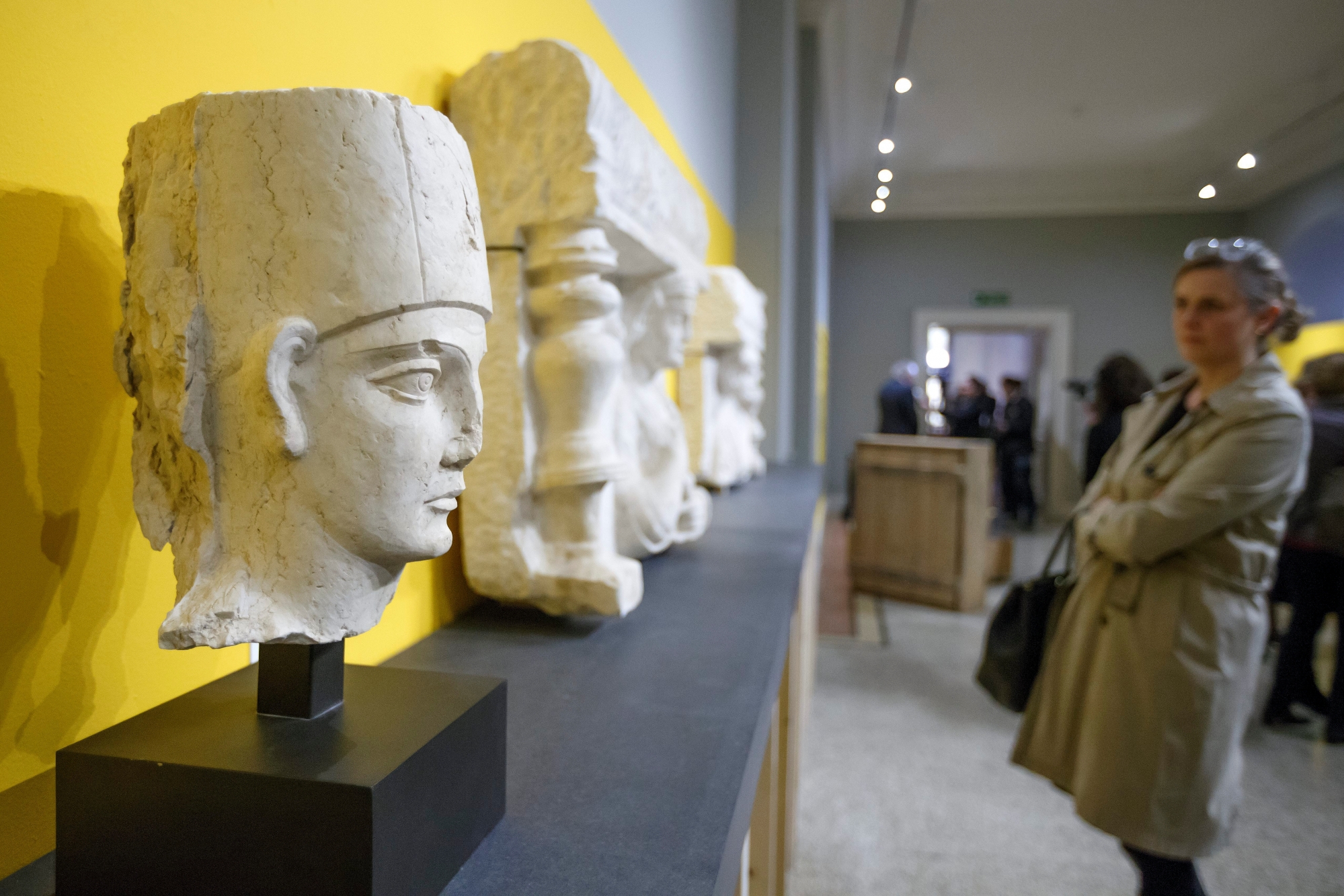 A person looks on a head of priest wearing cylindrical modius (of Palmyra) and two funerary artifacts of Palmyra, during a presentation of archaeological objects resulting from illicit trafficking, at the Musee d'Art et d'Histoire, in Geneva, Switzerland, on Tuesday, March 14, 2017. For a few months, the Musee d'Art et d'Histoire presents nine archaeological objects from Yemen, Syria and Libya, discovered by the Swiss Customs in 2013 at Geneva's Port Francs, resulting from the illicit traffic of cultural property and confiscated by the public prosecutor of Geneva. (KEYSTONE/Salvatore Di Nolfi) SWITZERLAND ARCHAEOLOGICAL ILLICIT TRAFFICKING