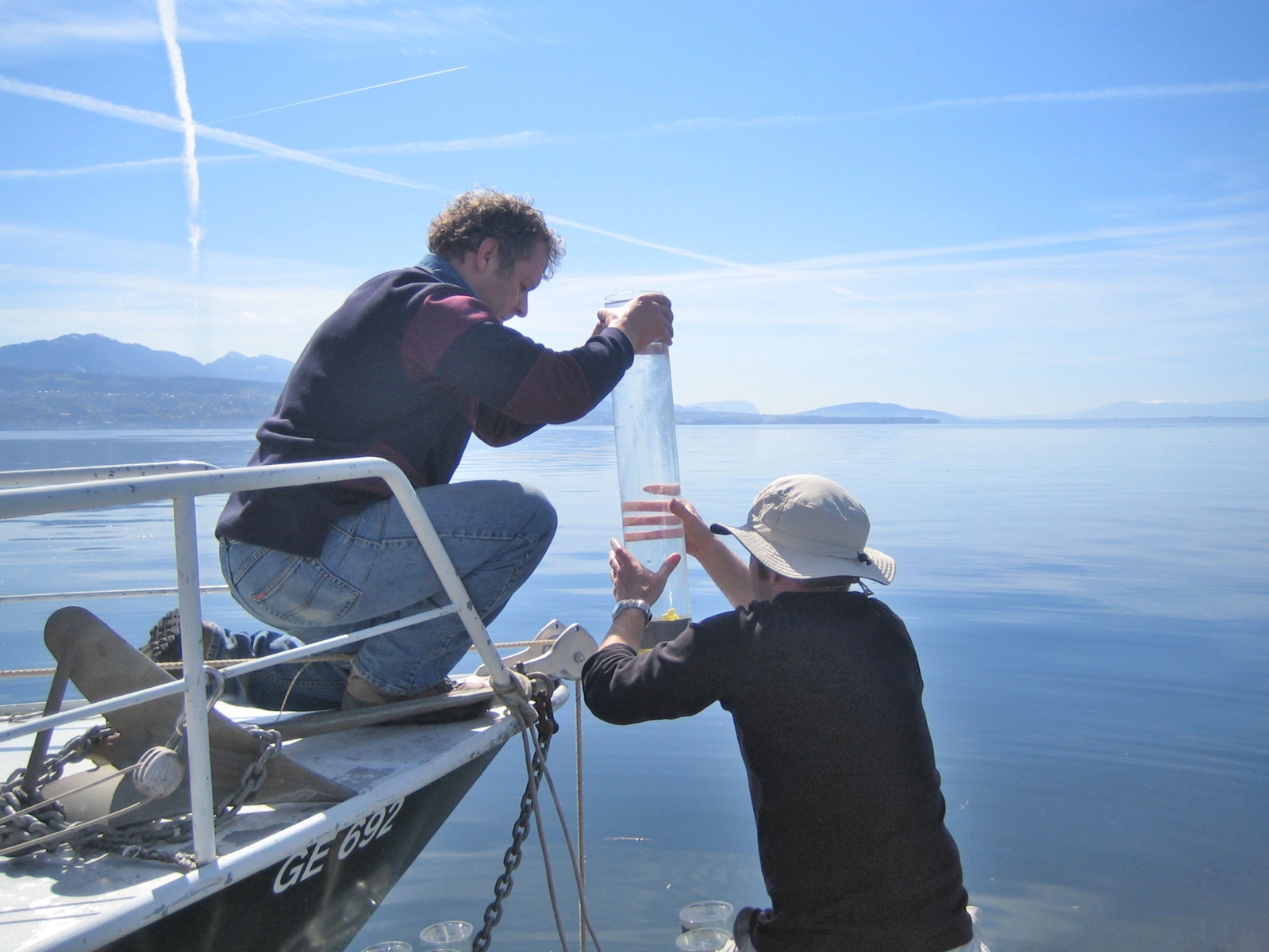 Jean-Luc Loizeau (à gauche) en train d'effectuer un prélèvement d'une carotte de sédiments dans le Lac Léman. 
