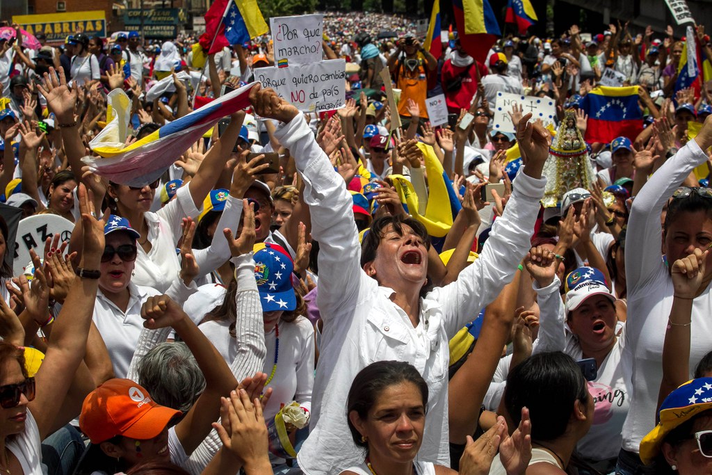 Vêtues de blanc, les femmes tenaient à la main des fleurs ou des pancartes condamnant la répression contre les opposants au Venezuela, où les violences ont fait 36 morts depuis le 1er avril. 