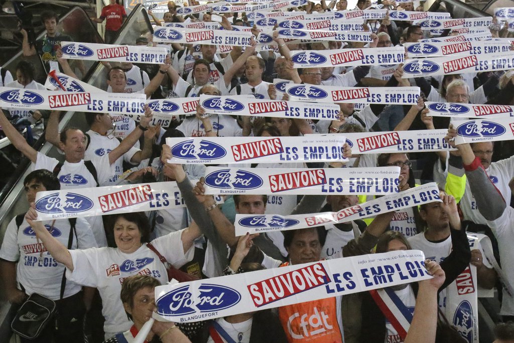 Les salariés de Ford ont traversé les allées du salon de l'auto de Paris bras levés en tenant des autocollants avec l'inscription «Ford, sauvons les emplois».