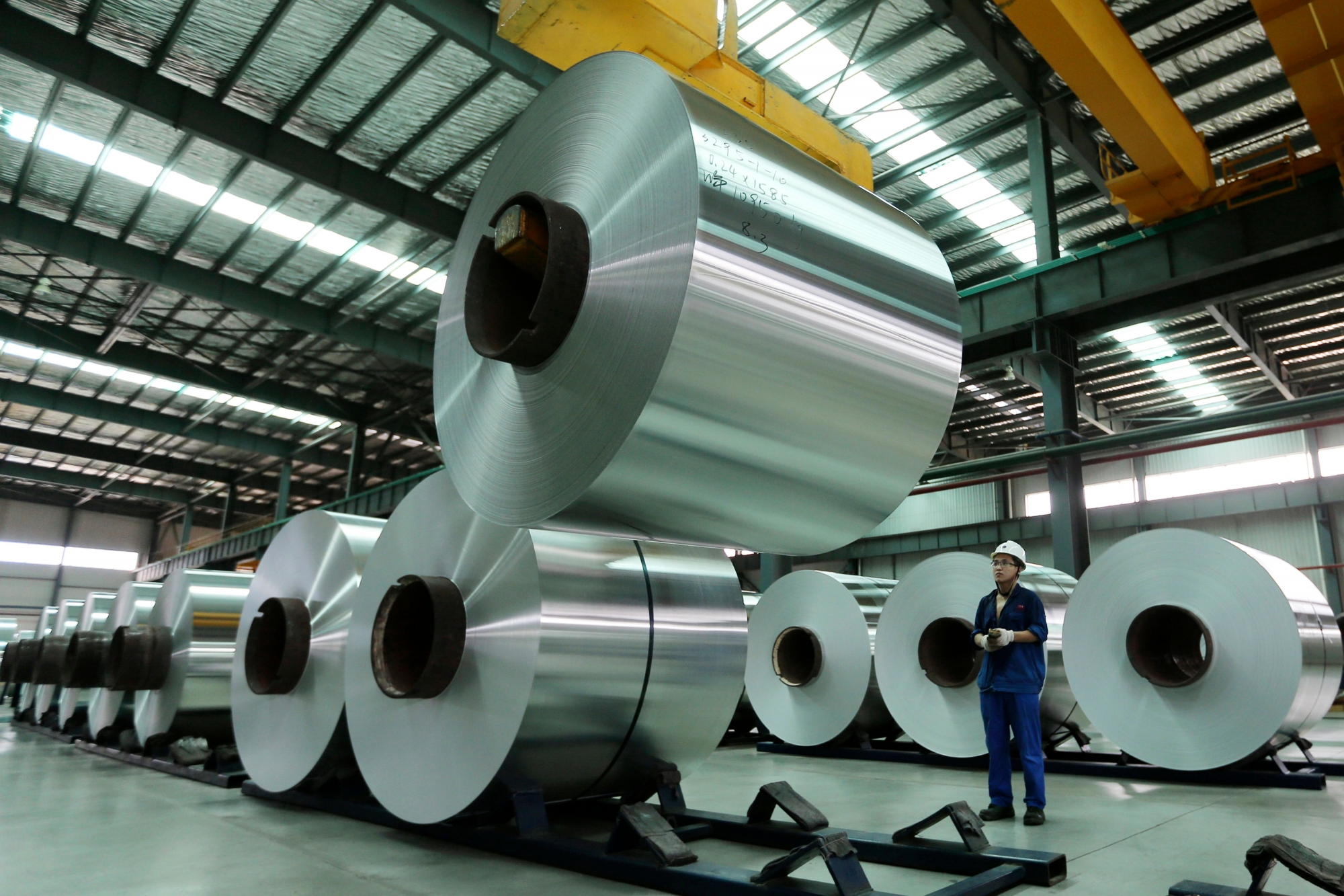 In this Aug. 3, 2017 photo, a worker arranges the aluminum rolls at a factory in Suixi county in central China's Anhui province. China's trade growth weakened in July in a negative sign for the country's economic growth and global demand. Customs data on Tuesday, Aug. 8, 2017 showed growth in exports decelerated to 7.2 percent from June's 11.3 percent. Imports rose 11 percent, down from the previous month's 17.2 percent. (Chinatopix via AP) CHINA OUT China Trade