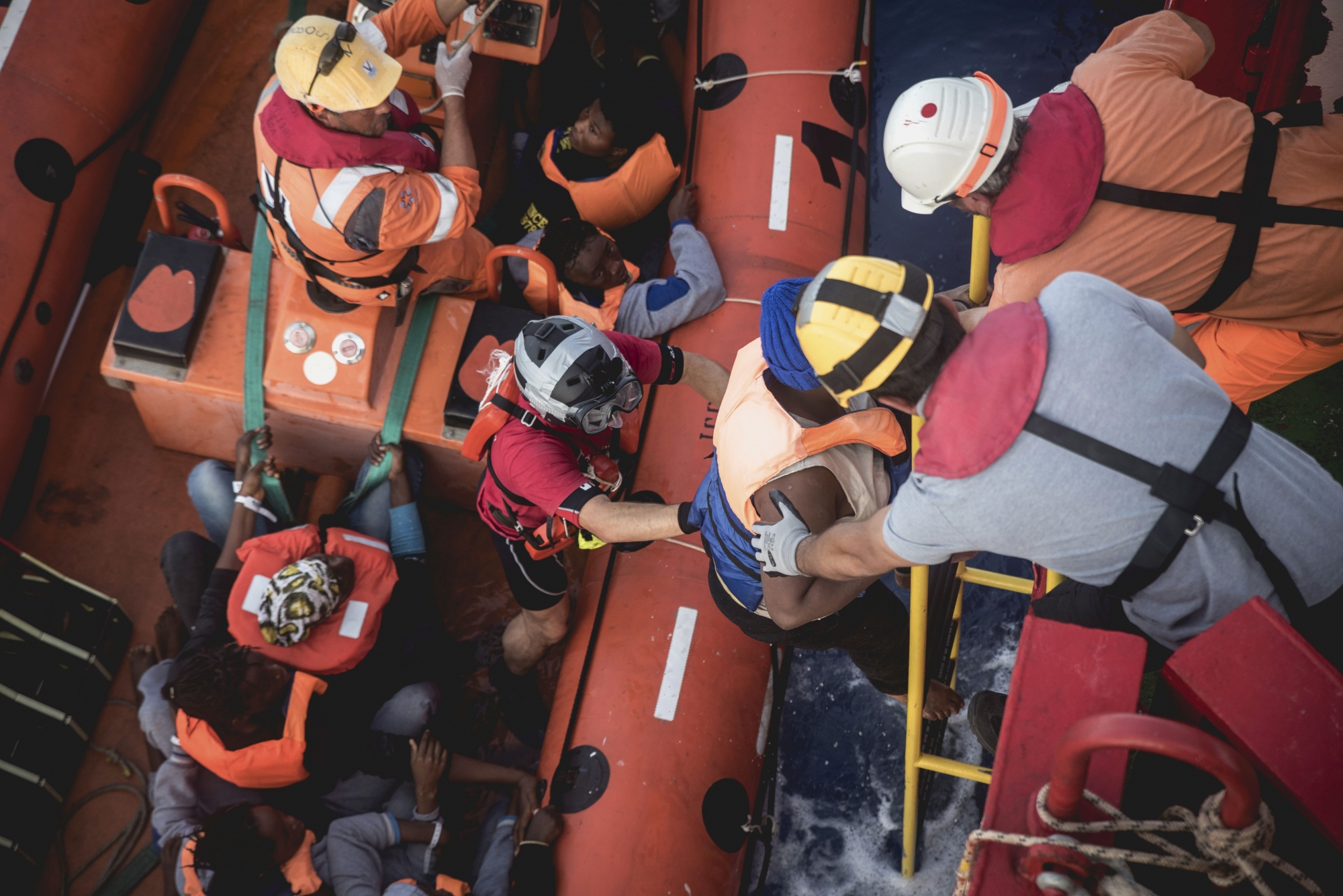 In this image made available Thursday Oct. 27, 2016, by Save The Children, workers with the international charitable organisation Save the Children assist migrants to board the Vos Hestia boat from a rib rescue craft, rescued from a migrant boat in the Mediterranean Sea, during a rescue operation off the coast of North Africa, in the Mediterranean Sea, Wednesday Oct. 26, 2016.  According to Save the Children, more than 290 people were brought aboard the Vos Hestia on Wednesday, along with 20 lifeless bodies. (Save The Children via AP) EUROPE MEDITERRANEAN MIGRANTS
