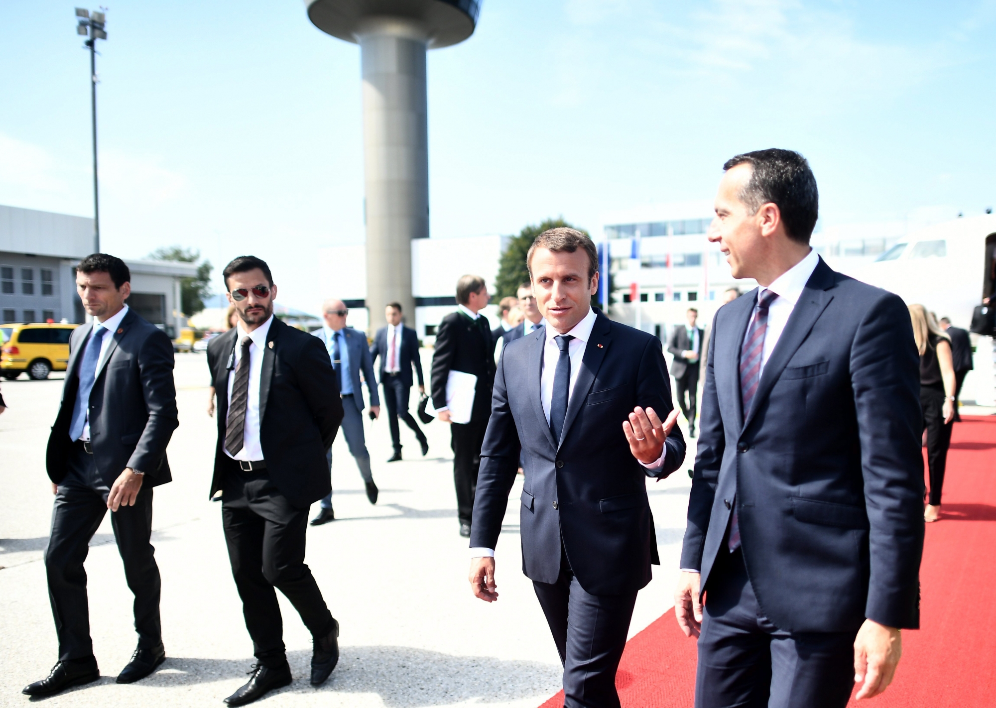 epa06157738 French President Emmanuel Macron (2-R) and Austrian Chancellor Christian Kern (R) talk at the Salzburg airport ahead of the Salzburg Summit of Heads of State and Government of the Republic of Austria, the French Republic, the Czech Republic and the Slovak Republic in Salzburg, Austria, 23 August 2017. Macron attends the 'Austerlitz Format', which includes Republic of Austria, Czech Republic and Slovak Republic, as a guest of honor in Salzburg.  EPA/CHRISTIAN BRUNA AUSTRIA SUMMITS