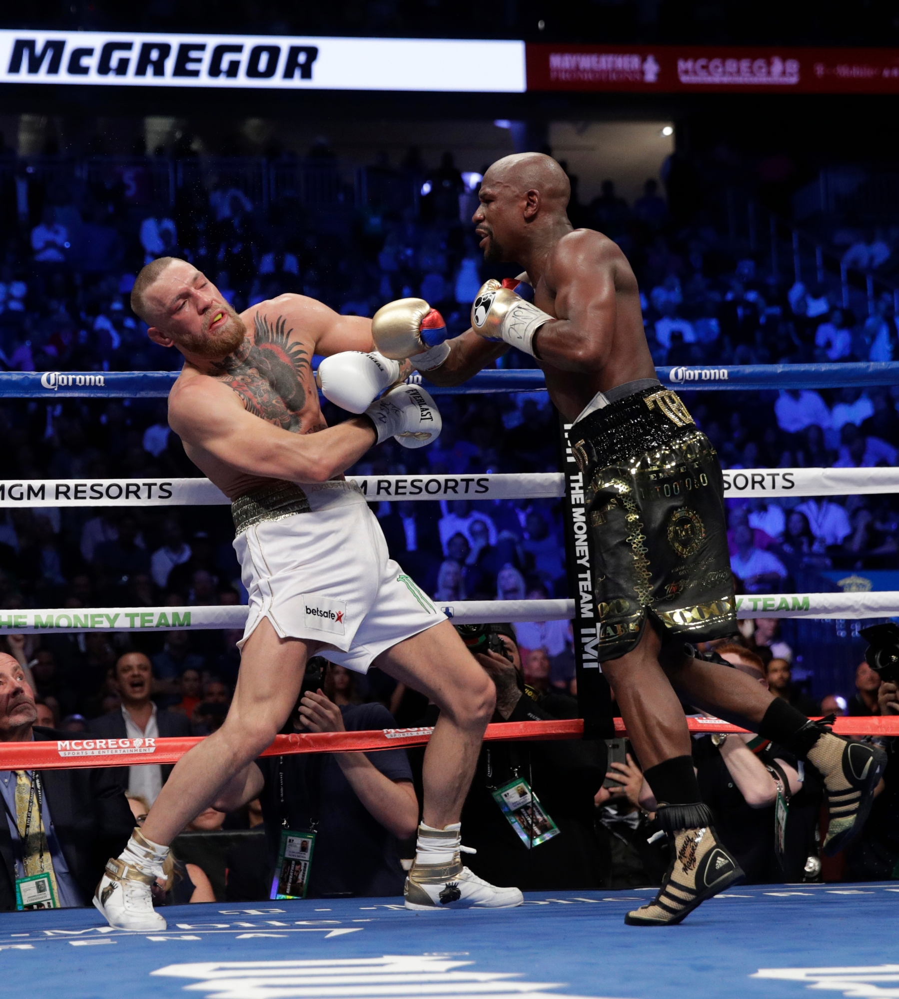 Floyd Mayweather Jr. hits Conor McGregor in a super welterweight boxing match Saturday, Aug. 26, 2017, in Las Vegas. (AP Photo/Isaac Brekken) Mayweather McGregor Boxing