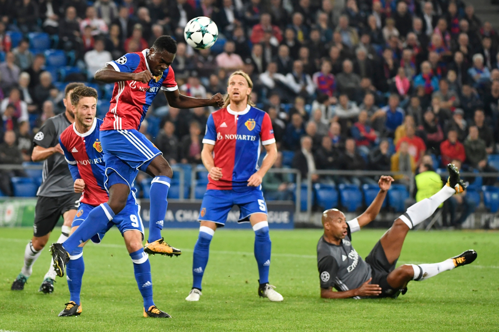 Basel's Dimitri Oberlin, 2nd left, tries a header in front of his teammates Ricky van Wolfswinkel, left, and Michael Lang, center, with Benfica's Luisao on the ground, right, during an UEFA Champions League Group stage Group A matchday 2 soccer match between Switzerland's FC Basel 1893 and Portugal's SL Benfica in the St. Jakob-Park stadium in Basel, Switzerland, on Wednesday, September 27, 2017. (KEYSTONE/Georgios Kefalas) SWITZERLAND SOCCER CHAMPIONS LEAGUE BASEL BENFICA