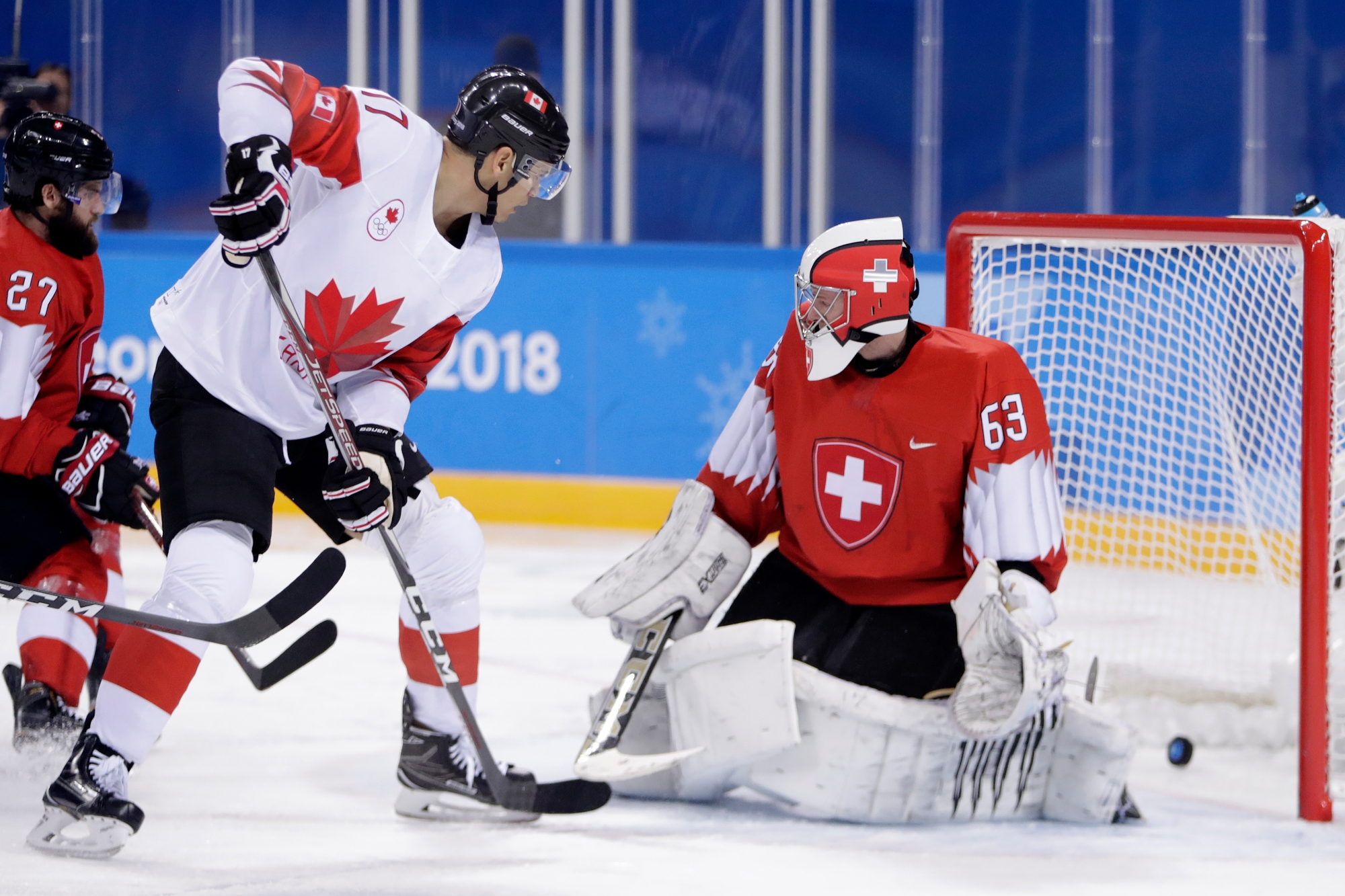 Rene Bourque, left, of Canada, scores a goal on Switzerland goalkeeper Leonardo Genoni during the second period of a preliminary round men's hockey game at the 2018 Winter Olympics in Gangneung, South Korea, Thursday, Feb. 15, 2018. (AP Photo/Julio Cortez) Pyeongchang Olympics Ice Hockey Men