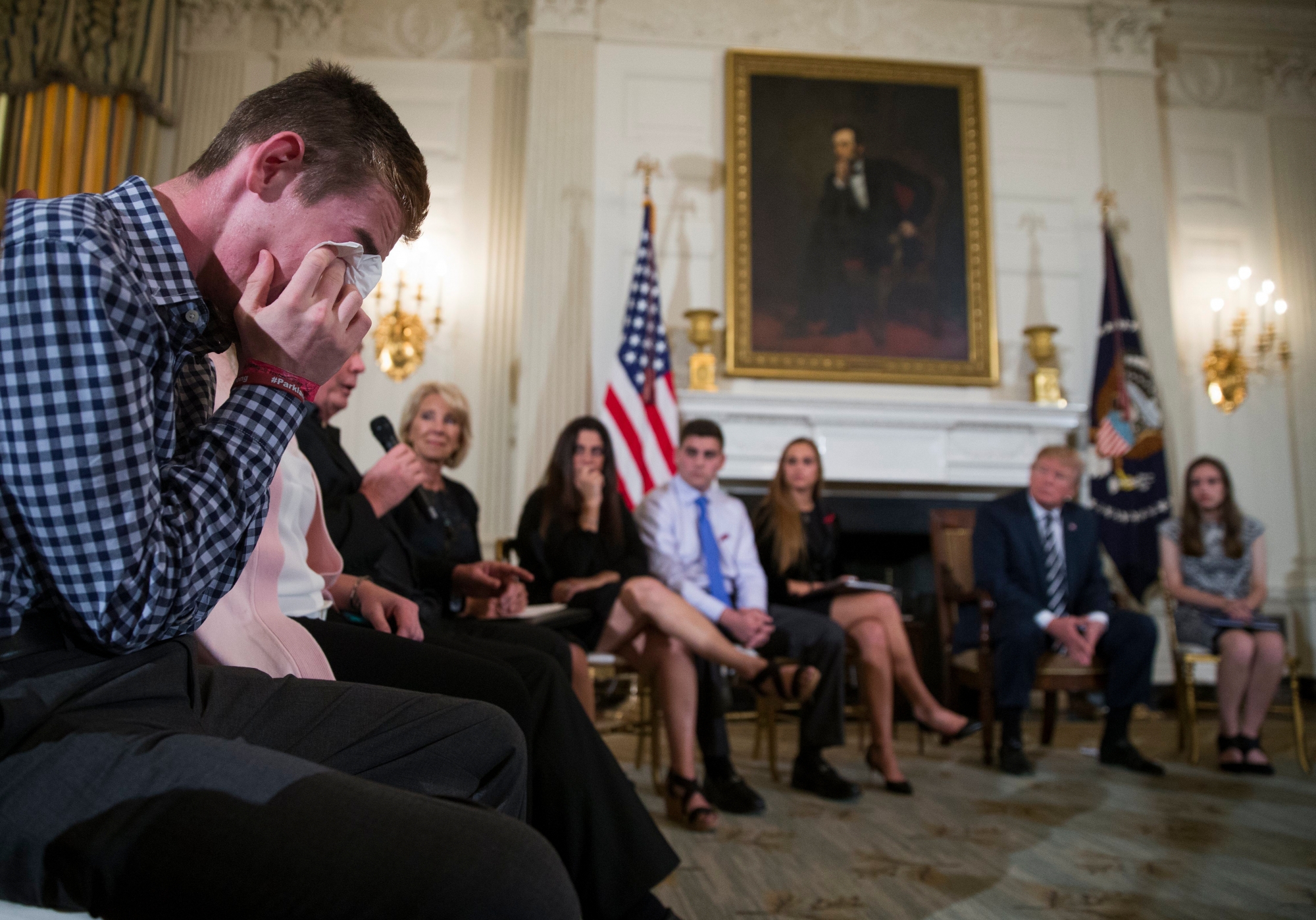 epa06551639 Marjory Stoneman Douglas High School shooting survivor Samuel Zeif (L) cries after delivering remarks as US President Donald J. Trump listens during a listening session with high school students and teachers in the State Dining Room of the White House in Washington, DC, USA, 21 February 2018. Families from the Parkland, Newtown and Columbine communities attended the meeting.  EPA/SHAWN THEW USA TRUMP GUN CONTROL