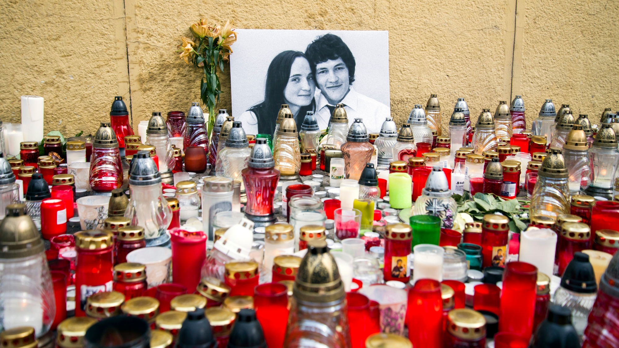 Candles are left in tribute to murdered Slovakian investigative reporter Jan Kuciak, 27, and his fiancee Martina, 27, at Slovak National Uprising Square in Bratislava, on Tuesday, Feb. 27, 2018. A leading Slovak newspaper says organized crime may have been involved in the shooting death of an investigative journalist that shocked Slovakia. The bodies of Kuciak and Kusnirova were found Sunday evening in their house in the town of Velka Maca, east of the capital, Bratislava. (Jakub Kotian/TASR via AP) Slovakia Journalist Killed