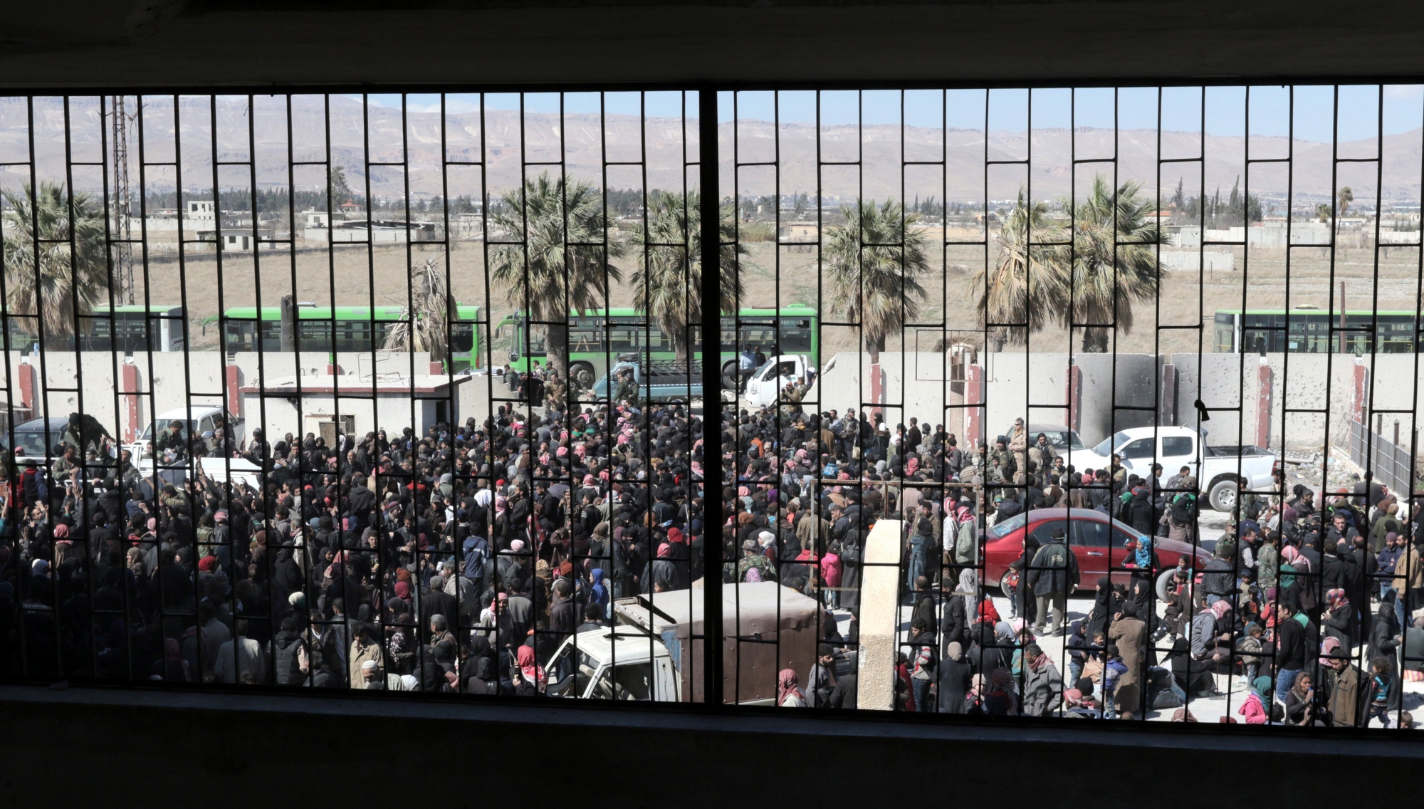 epaselect epa06608241 Hundreds of civilians, who were evacuated from the Eastern Ghouta, wait for buses to transport them for nearby makeshift centers, at Housh Nasri area, outskirts of Damascus, Syria, 16 March 2018. According to media reports, the Syrian army and the Syrian Arab Red Crescent (SARC) evacuated the civilians via Hamoria corridor. The reports said that the Syrian army has recaptured around 70 percent of Eastern Ghouta since the start of the military offensive. On 19 February 2018 the Syrian government started a military campaign to regain control of rebels-held Eastern Ghouta in Damascus's countryside. Around 1500 civilians were killed according to local reports.  EPA/YOUSSEF BADAWI epaselect SYRIA CONFLICT EASTERN GHOUTA EVACUATION