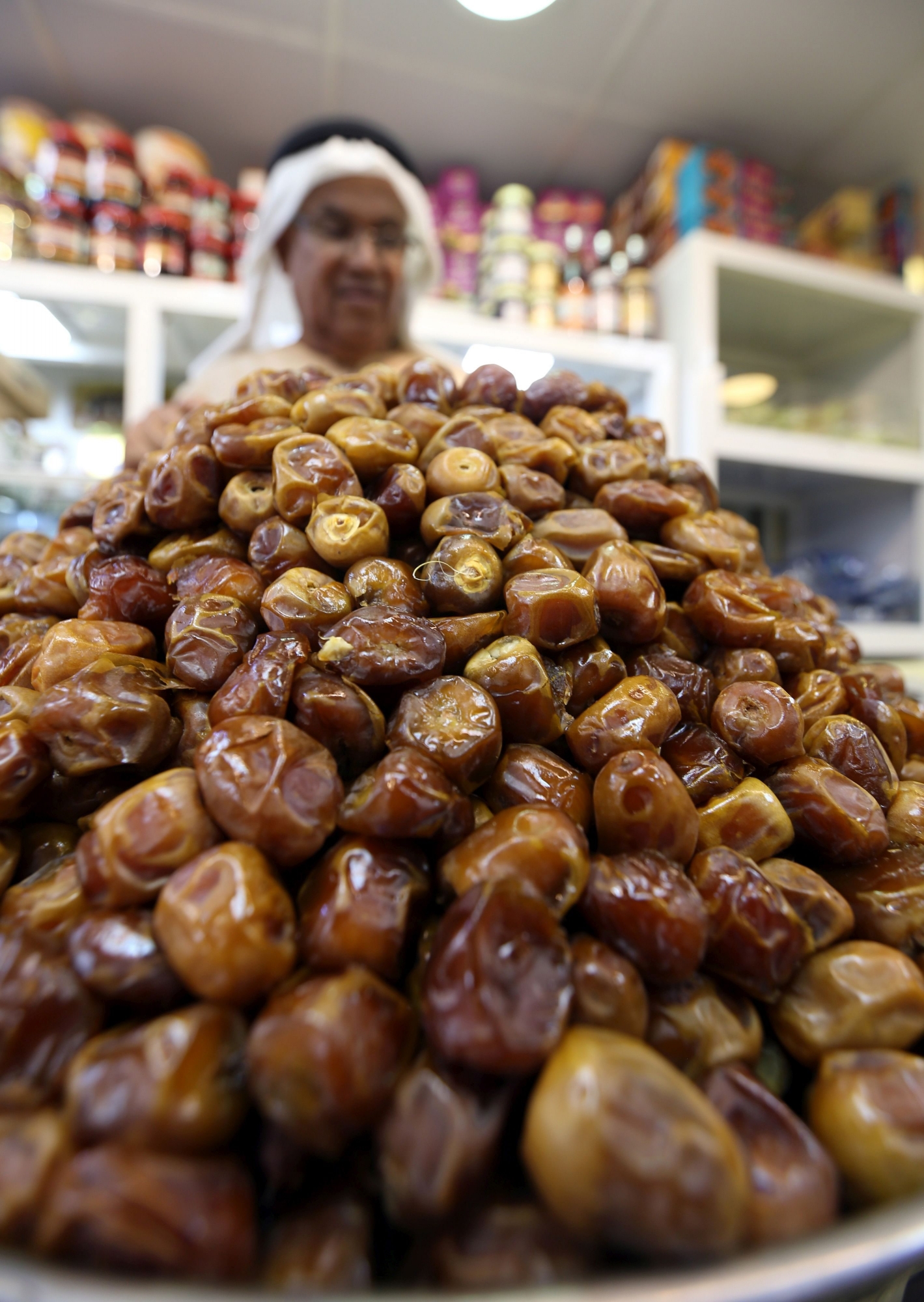 epa06738635 A shopper at a popular vegetables market selects dates, an important Ramadan staple, before the starting of the Islamic holy month of Ramadan, Abu Dhabi, United Arab Emirates, 15 May 2018. Muslims are shopping for food and sweets as part of their preparations for one of the most important dates in the Islamic calendar, Ramadan, expected to start 17 May. Muslims around the world celebrate the holy month of Ramadan by praying during the night time and abstaining from eating, drinking, and sexual acts during the period between sunrise and sunset. Ramadan is the ninth month in the Islamic calendar and it is believed that the revelation of the first verse in Koran was during its last 10 nights.  EPA/ALI HAIDER UAE RAMADAN ISLAM BELIEF