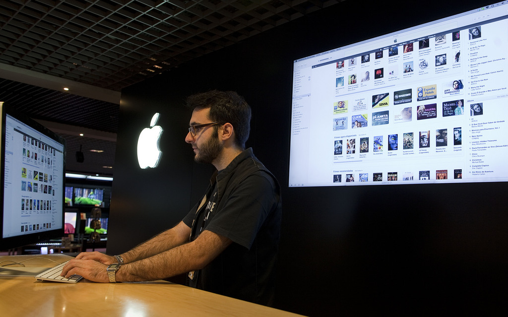 An employee at an Apple store checks the iTunes store on a computer as he works in Sao Paulo, Brazil, Tuesday Dec. 13, 2011.  Apple says it launched iTunes on Tuesday in Brazil and 15 other Latin American countries. (AP Photo/Andre Penner)