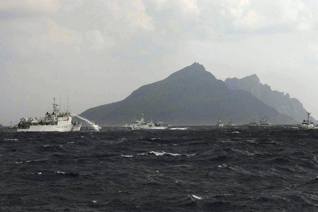 In this photo released by Taiwan's Central News Agency, a Taiwan Coast Guard patrol boat, left, sprays its water cannon towards a Japan Coast Guard patrol boat off the disputed islands called Senkaku in Japan and Diaoyu in China, in the East China Sea, Tuesday, Sept. 25, 2012. On Tuesday morning, about 50 Taiwanese fishing boats accompanied by 10 Taiwanese surveillance ships came within almost 20 kilometers (about 12 miles) of the disputed islands- within what Japan considers to be its territorial waters. (AP Photo/Central News Agency) TAIWAN OUT