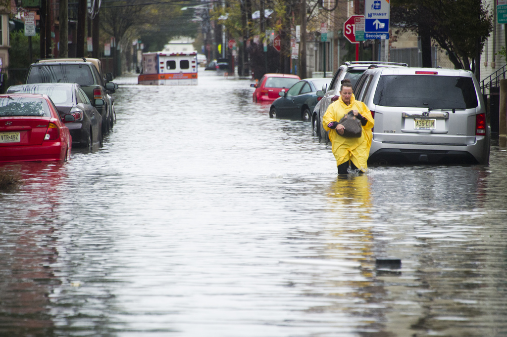 A resident walks through flood water and past a stalled ambulance in the  aftermath of superstorm Sandy on Tuesday, Oct. 30, 2012 in Hoboken, NJ. (AP Photo/Charles Sykes)