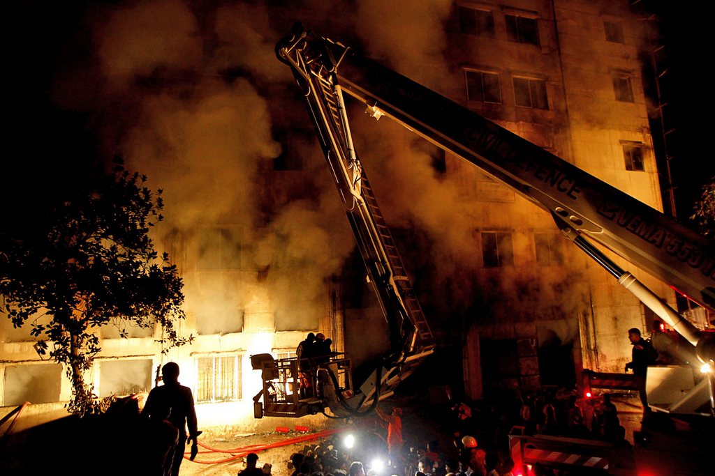 Bangladeshi firefighters battle a fire at a garment factory in the Savar neighborhood in Dhaka, Bangladesh, late Saturday, Nov. 24, 2012. At least 112 people were killed in a fire that raced through the multi-story garment factory just outside of Bangladesh's capital, an official said Sunday.  (AP Photo/Hasan Raza)