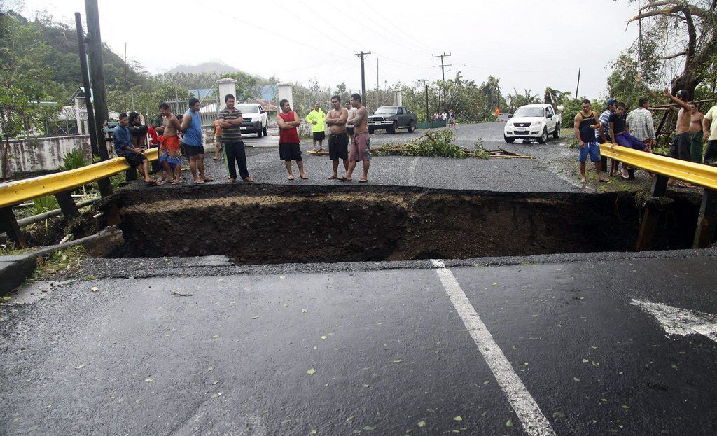 Des Samoans obserfvent les dégâts sur un pont à Apia. 