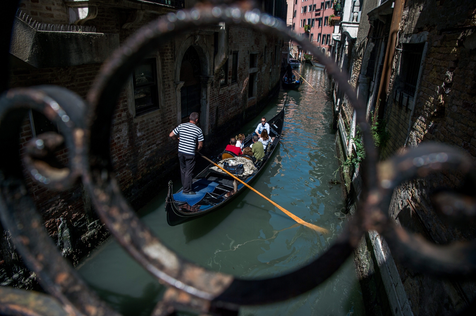 epa06764388 A gondola rider is seen in a canal of Venice, Italy, 25 May 2018. According to reports, some 30 million tourists visited the most popular tourism city in 2017 that revealed plans to curb the numbers of visitors per day.  EPA/Zoltan Balogh HUNGARY OUT ITALY TRAVEL VENICE TOURISM