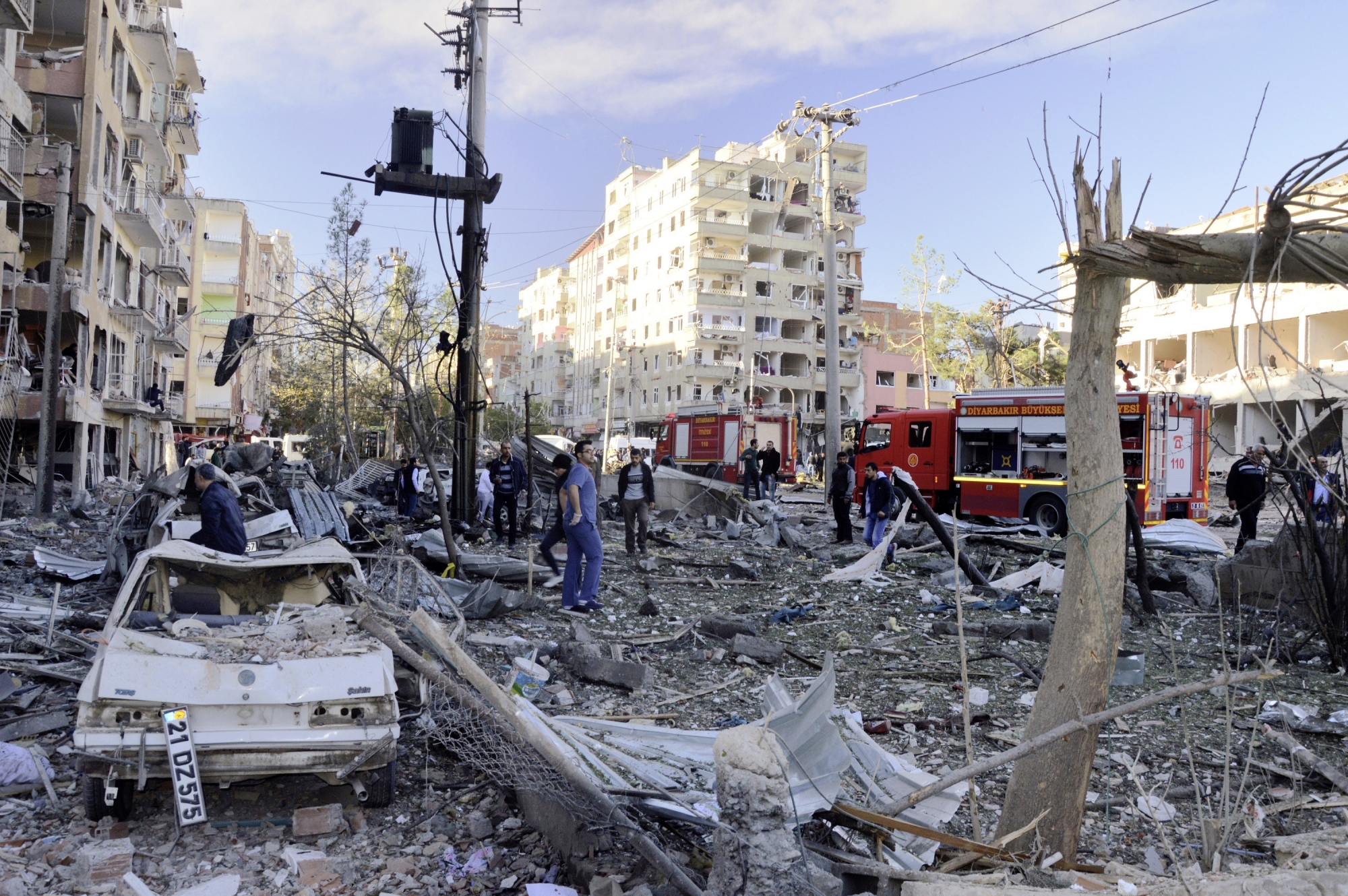 People watch the damage after an explosion in southeastern Turkish city of Diyarbakir, early Friday, Nov. 4, 2016. A large explosion hit the largest city in Turkey's mainly Kurdish southeast region on Friday, wounding several people, the state-run Anadolu Agency reported. The cause of the explosion was not immediately known but Hurriyet newspaper said it may have been caused by a car bomb. (IHA via AP) APTOPIX Turkey Explosion
