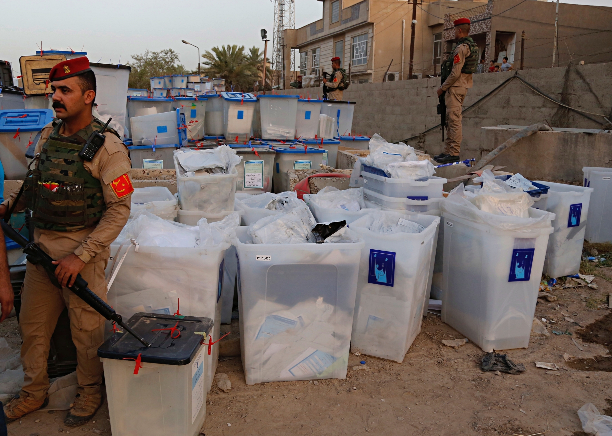 Iraqi security forces guard ballot boxes after a fire that broke out at Baghdad's largest ballot box storage site, where ballots from Iraq's May parliamentary elections are stored, in Baghdad, Iraq, Sunday, June 10, 2018. The ballots are part of a manual recount of votes, mandated in a law passed by the Iraqi parliament last Wednesday. (AP Photo/Karim Kadim) Iraq Fire