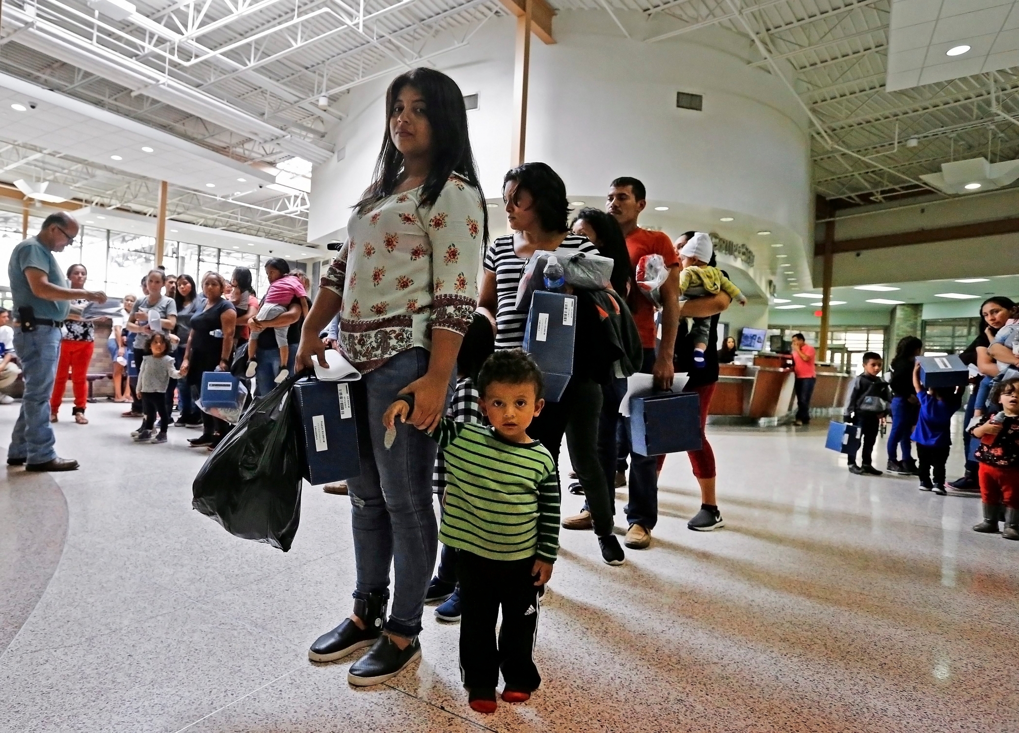 epa06843038 Migrant families are processed at the Central Bus Station before being taken to Catholic Charities in McAllen, Texas, USA, 26 June 2018. Immigration along the Rio Grande in Texas has become a political issue, due to the controversy surrounding the US Justice Department's suspended 'Zero Tolerance' policy of criminally prosecuting all migrants entering the country illegally and the now-reversed policy of separating migrant children from their parents.  EPA/LARRY W. SMITH USA IMMIGRATION