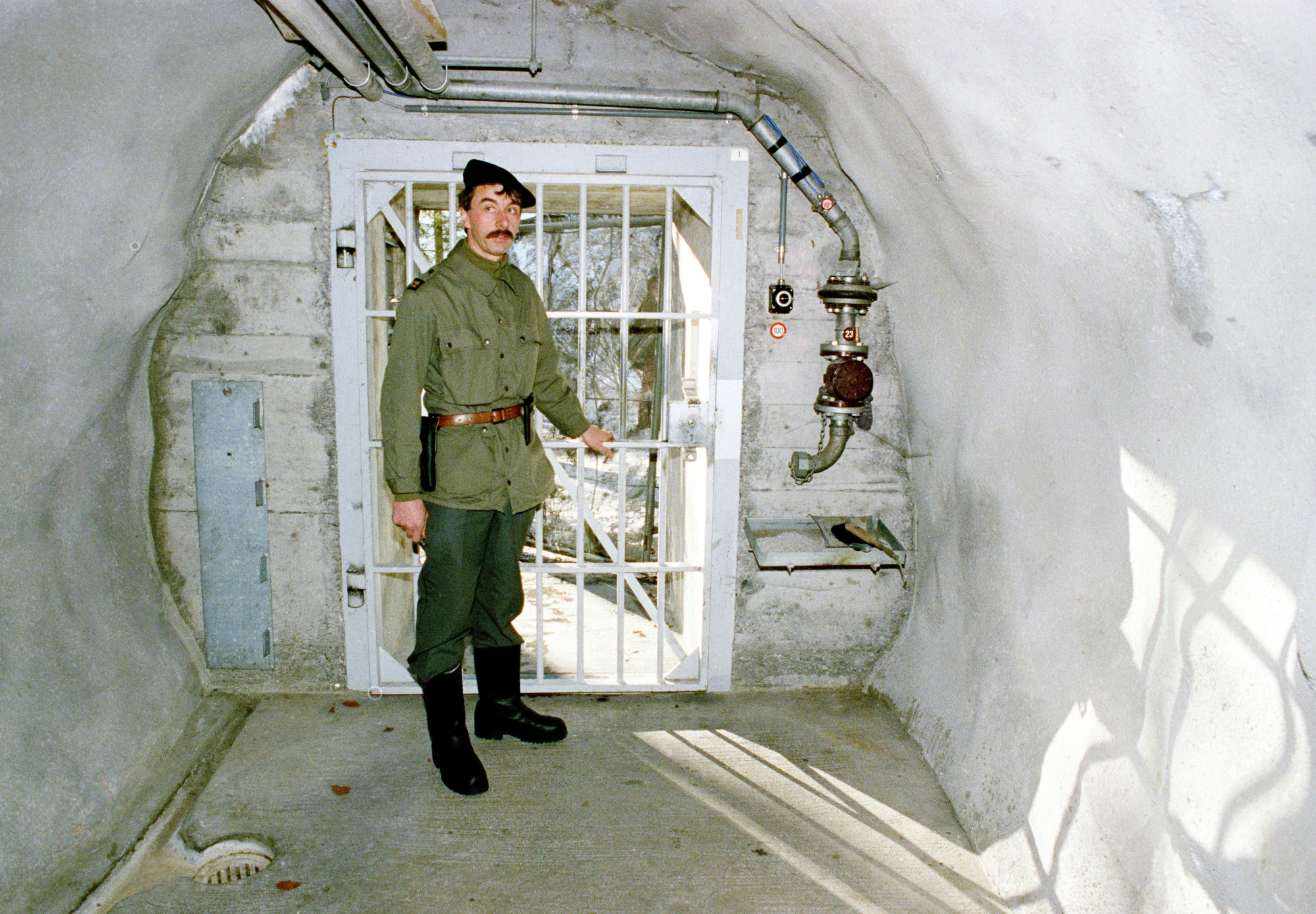 Ein Soldat steht anlaesslich einer Pressefuehrung zur Information ueber die Geheimarmee P-26 beim Eingang der unterirdischen Bunkeranlage bei Gstaad im Berner Oberland, aufgenommen am 7. Dezember 1990. Der Stuetzpunkt diente der Geheimorganisation als Waffenlager und Ausbildungsanlage. (KEYSTONE/Str) SCHWEIZ GEHEIMARMEE P-26