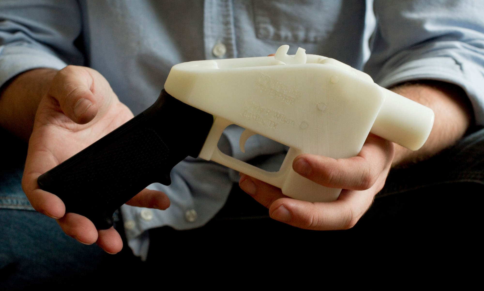 FILE - In this May 10, 2013, file photo, Cody Wilson holds what he calls a Liberator pistol that was completely made on a 3-D-printer at his home in Austin, Texas. Eight states filed suit Monday, July 30, 2018, against the Trump administration over its decision to allow a Texas company to publish downloadable blueprints for a 3D-printed gun, contending the hard-to-trace plastic weapons are a boon to terrorists and criminals and threaten public safety. (Jay Janner/Austin American-Statesman via AP, File) 3D Guns