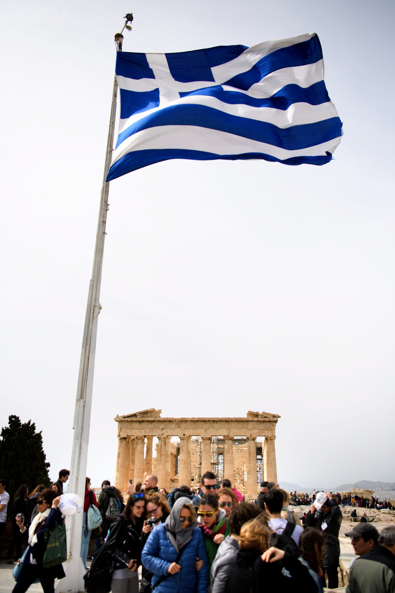 Tourists taking pictures under the Greece flag in front of the Parthenon at the Acropolis Hill, in Athens, Greece, Wednesday, March 21, 2018. (KEYSTONE/Laurent Gillieron)
 GREECE ATHENS