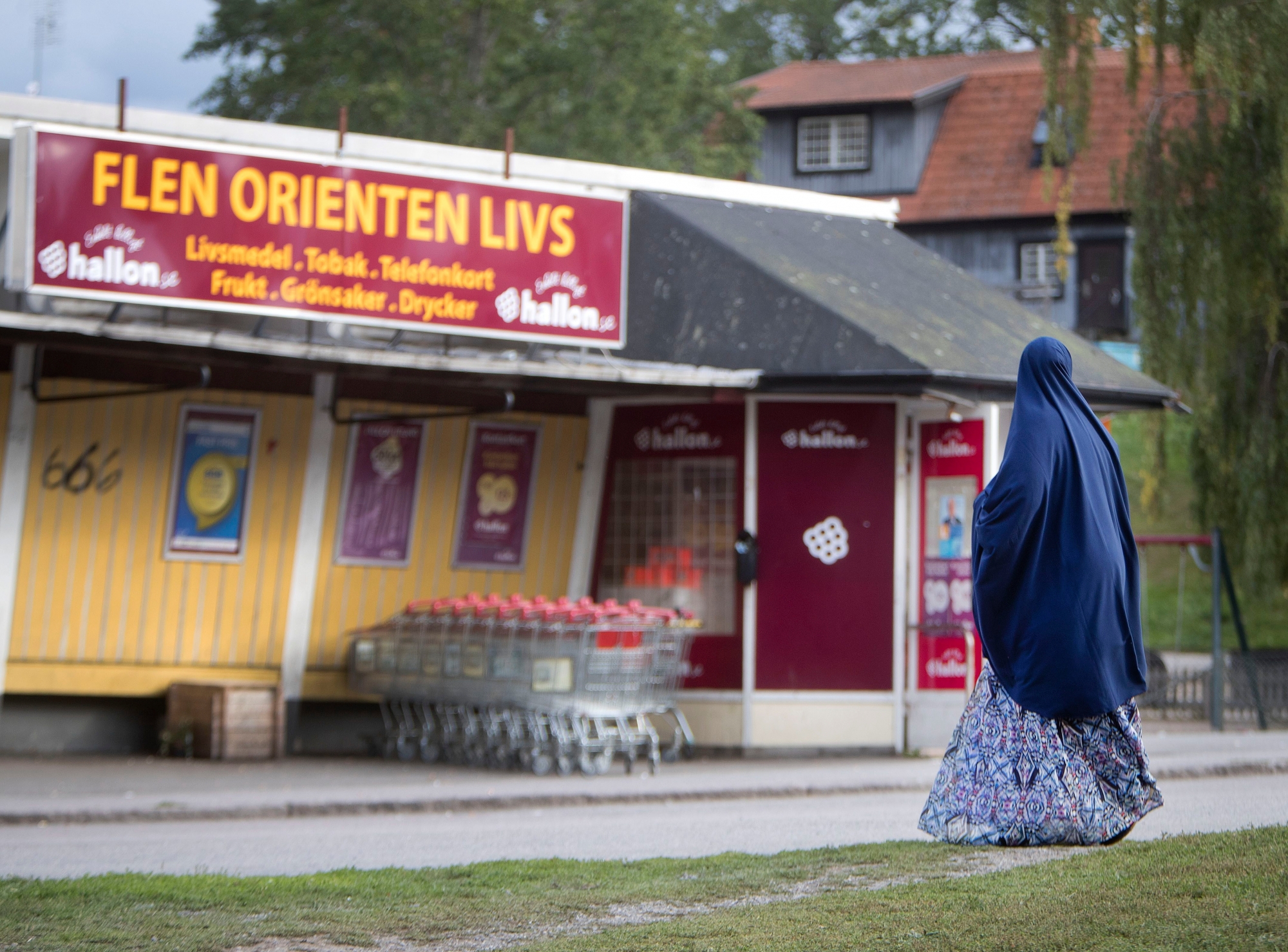 In this Aug. 30, 2018 photo a migrant woman stands in front of an orient supermarket in Flen, some 100 km west of Stockholm, Sweden. The town has welcomed so many asylum seekers in recent years that they now make up about a fourth of the population.  (AP Photo/Michael Probst) Sweden Elections