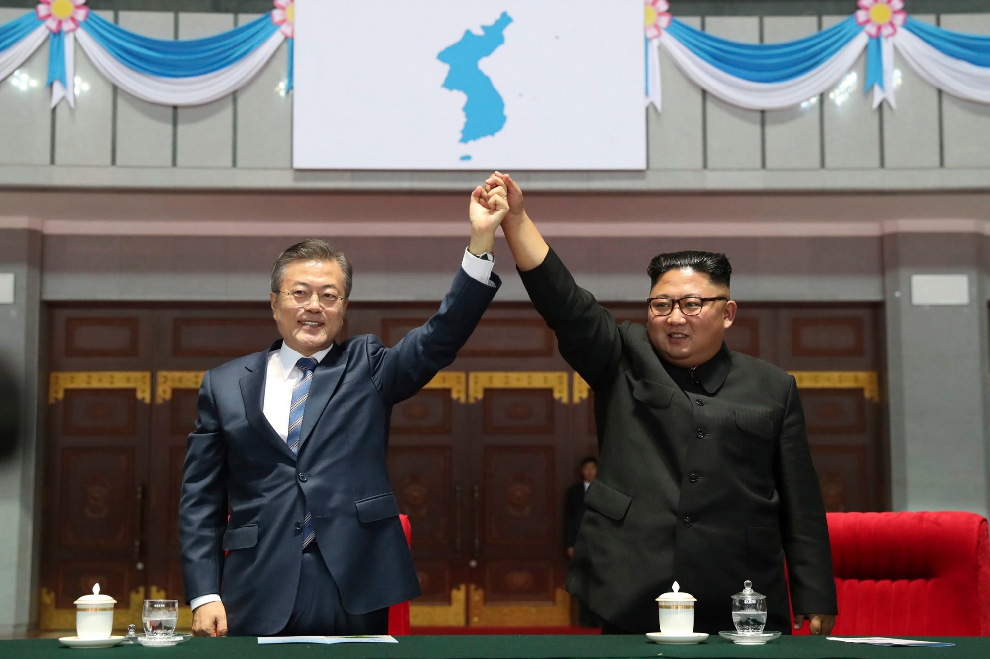 South Korean President Moon Jae-in and North Korean leader Kim Jong Un raise their hands after watching the mass games performance of "The Glorious Country" at May Day Stadium in Pyongyang, North Korea, Wednesday, Sept. 19, 2018. (Pyongyang Press Corps Pool via AP) North Korea Koreas Summit