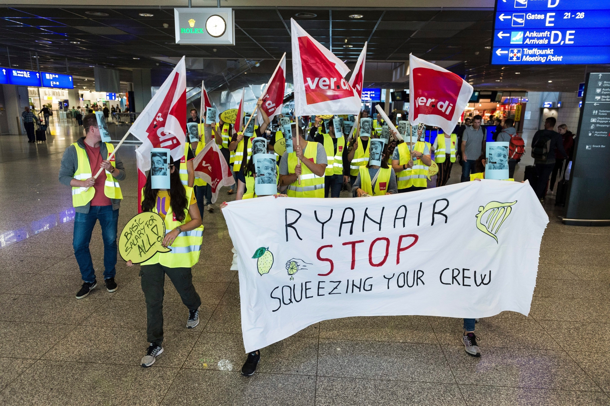 Ryanair employees wear masks with a photo of Ryanair CEO Michael O'Leary during a protest at the airport in Frankfurt, Germany, Wednesday, Sept. 12, 2018. Ryanair employees are on a 24 hrs strike in Germany on Wednesday. (Silas Stein/dpa via AP) Germany Ryanair Strike