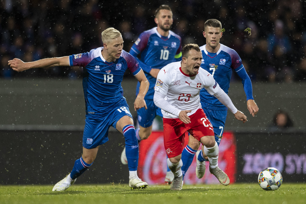 Iceland's Hoerdur Magnusson left, fights for the ball against Switzerland's Xherdan Shaqiri, right, during the UEFA Nations League soccer match between Iceland and Switzerland at the Laugardalsvoellur stadium in Reykjavik, Iceland, on Monday, October 15, 2018. (KEYSTONE/Ennio Leanza)