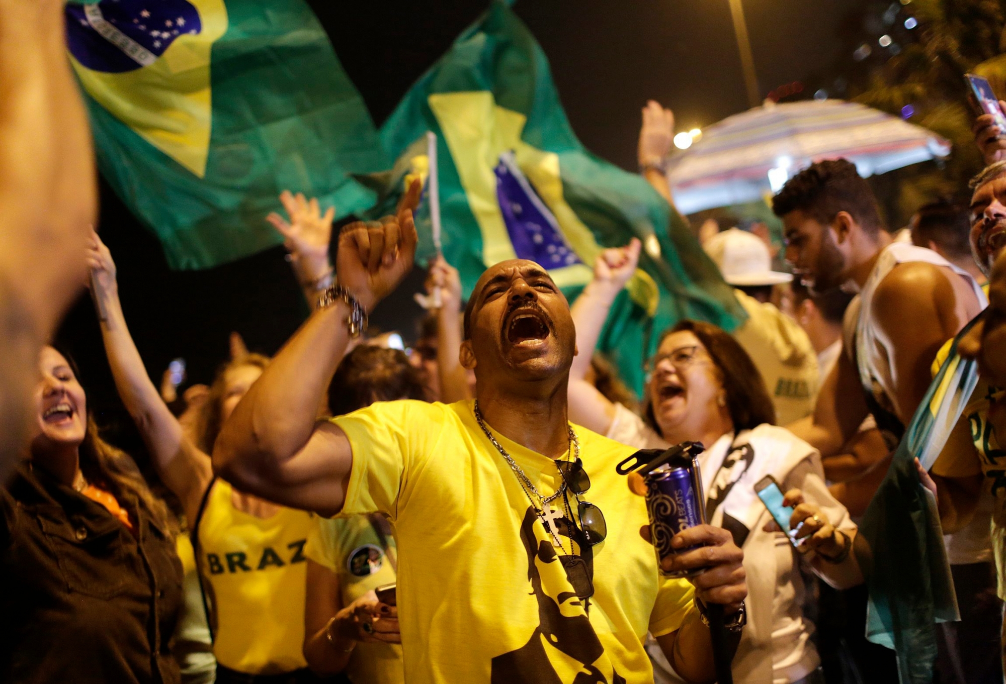 Supporters of presidential candidate Jair Bolsonaro celebrate in front of his residence after he was declared the winner of the election run off, in Rio de Janeiro, Brazil, Sunday, Oct. 28, 2018. BrazilÄôs Supreme Electoral Tribunal declared the far-right congressman the next president of Latin AmericaÄôs biggest country, with 96 percent of ballots counted. (AP Photo/Silvia Izquierdo) Brazil Elections