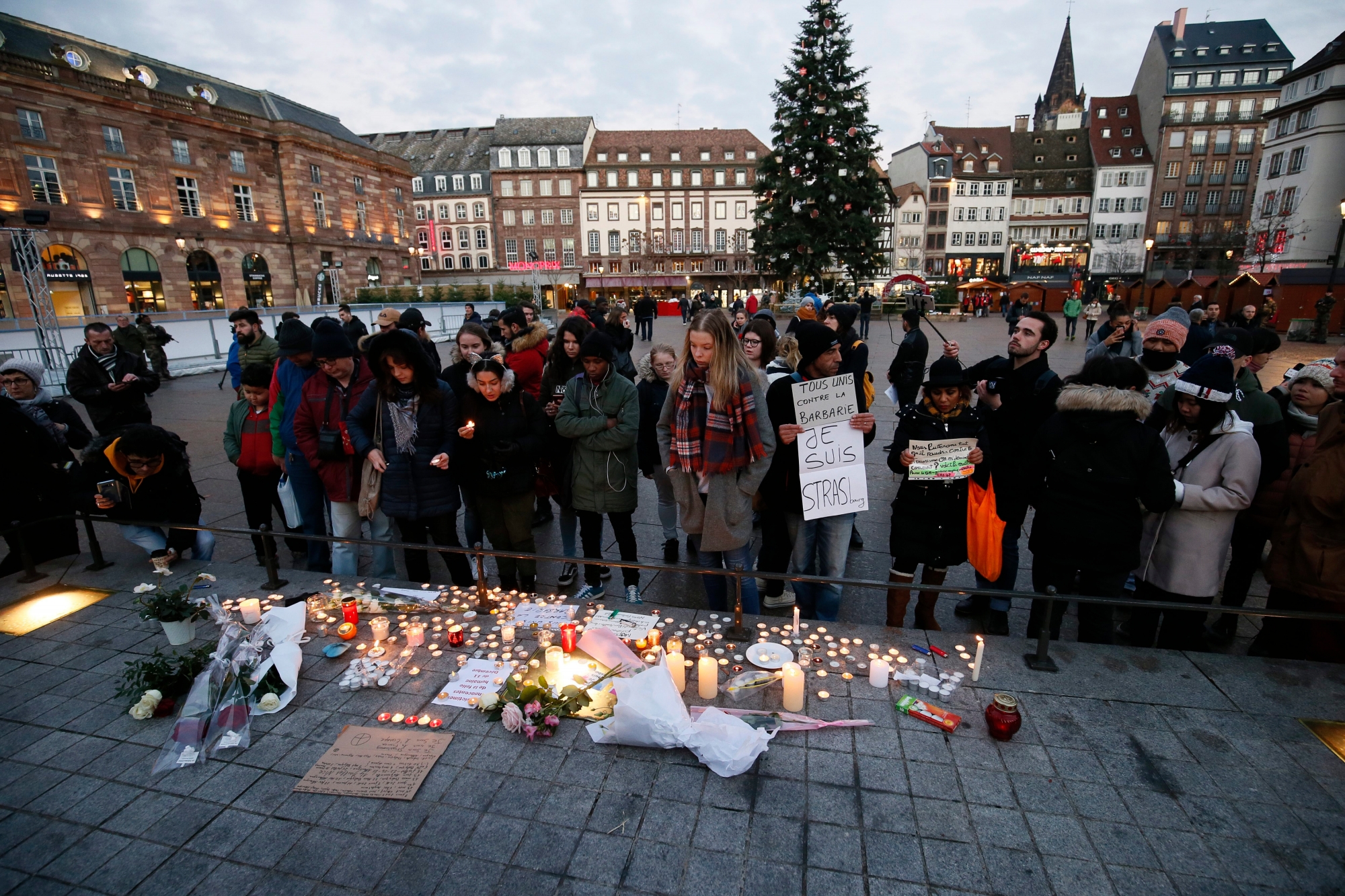epa07226274 People light candles and leave signs and flowers on a place close to the Christmas Market where a shooting happened in Strasbourg, France, 12 December 2018. According to latest reports, three people were killed and several injured when a gunman opened fire at the Strasbourg Christmas market a day earlier. The suspect is reported to be at large and the motive for the attack is still unclear.  EPA/RONALD WITTEK FRANCE SHOOTING AFTERMATH