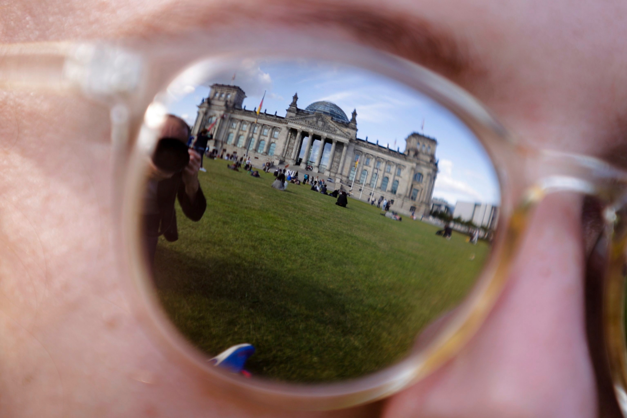 FILE - The Sept. 22, 2017 file photo shows the Reichstag building, which host the German parliament Bundestag as it is reflected in the sunglasses of a woman in Berlin. German Interior Minister Horst Seehofer will inform in a press conference on Tuesday, Jan. 8, 2019 on an alleged hacking case that saw hundreds of politicians' and celebrities' private information posted online. (AP Photo/Markus Schreiber, file) Germany Politicians Hacked