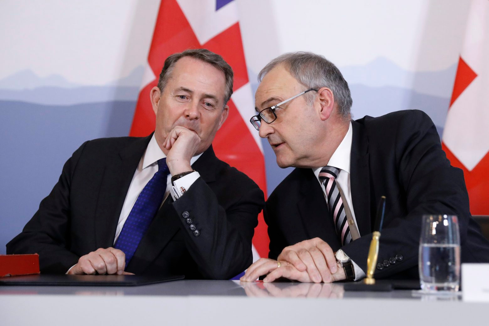 Swiss Federal Councillor Guy Parmelin, right, talks to British Secretary of State for International Trade Liam Fox, left, after signing a trade agreement in Bern, Switzerland, Monday, February 11, 2019. Parmelin and Fox signed a bilateral trade agreement regulating relations between the two countries after the Brexit. Because of the customs treaty with Switzerland, the agreement also applies to Liechtenstein. (KEYSTONE/Peter Klaunzer) SWITZERLAND UNITED KINGDOM LIECHTENSTEIN TRADE AGREEMENT