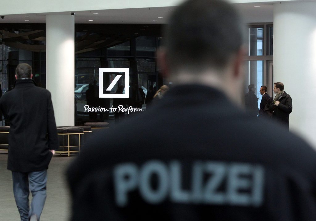 epa03505743 A police officer stands at the entrance of the head office of Deutsche Bank in Frankfurt am Main, Germany, 12 December 2012. German prosecutors issued arrest has  warrants for five employees of Deutsche Bank on suspicion of money laundering and obstruction of justice following raids on the lender. About 500 police officers as well as tax investigators searched the Frankfurt headquarters of Germany's biggest bank, along with several apartments and businesses in Berlin and Dusseldorf as part of a two-year investigation into tax evasion involved in the trading of carbon emission permits. In 2010, 25 employees were investigated on suspicion of money laundering and obstruction of justice following similar raids on the bank. In December 2011, a German court sentenced six men to jail for their involvement in a scheme to evade a minimum of 230 million euros (300 million dollars) in value-added tax (VAT) on the trade in CO2 certificates linked to Deutsche Bank.  EPA/FRANK RUMPENHORST